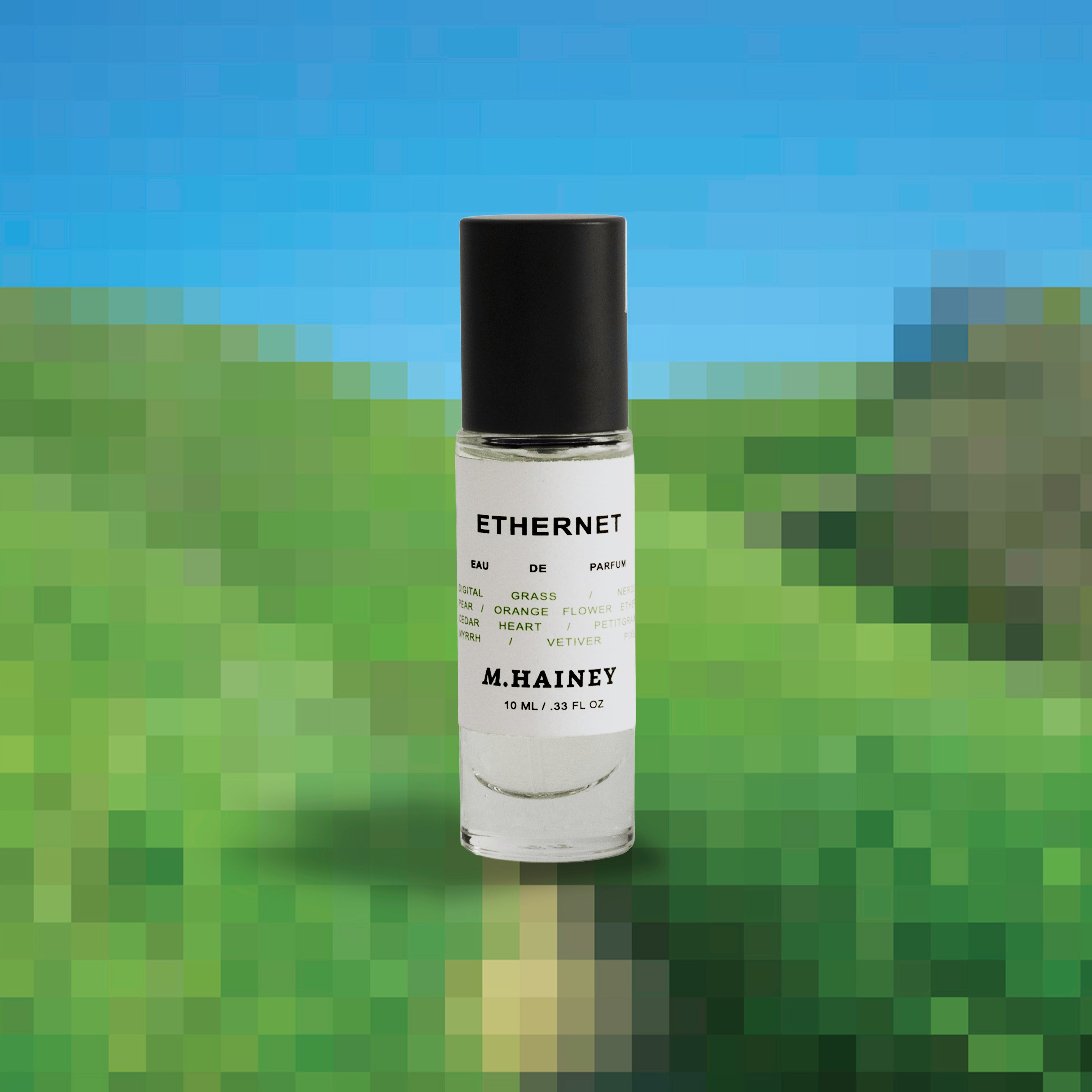 Perfume bottle labeled 'Ethernet' by M. Hainey on a blurred green and blue background