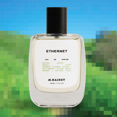 M.Hainey Ethernet perfume bottle with a blurred green and blue background