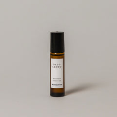 Bottle of Palo Santo perfume by M. Hainey on a gray background