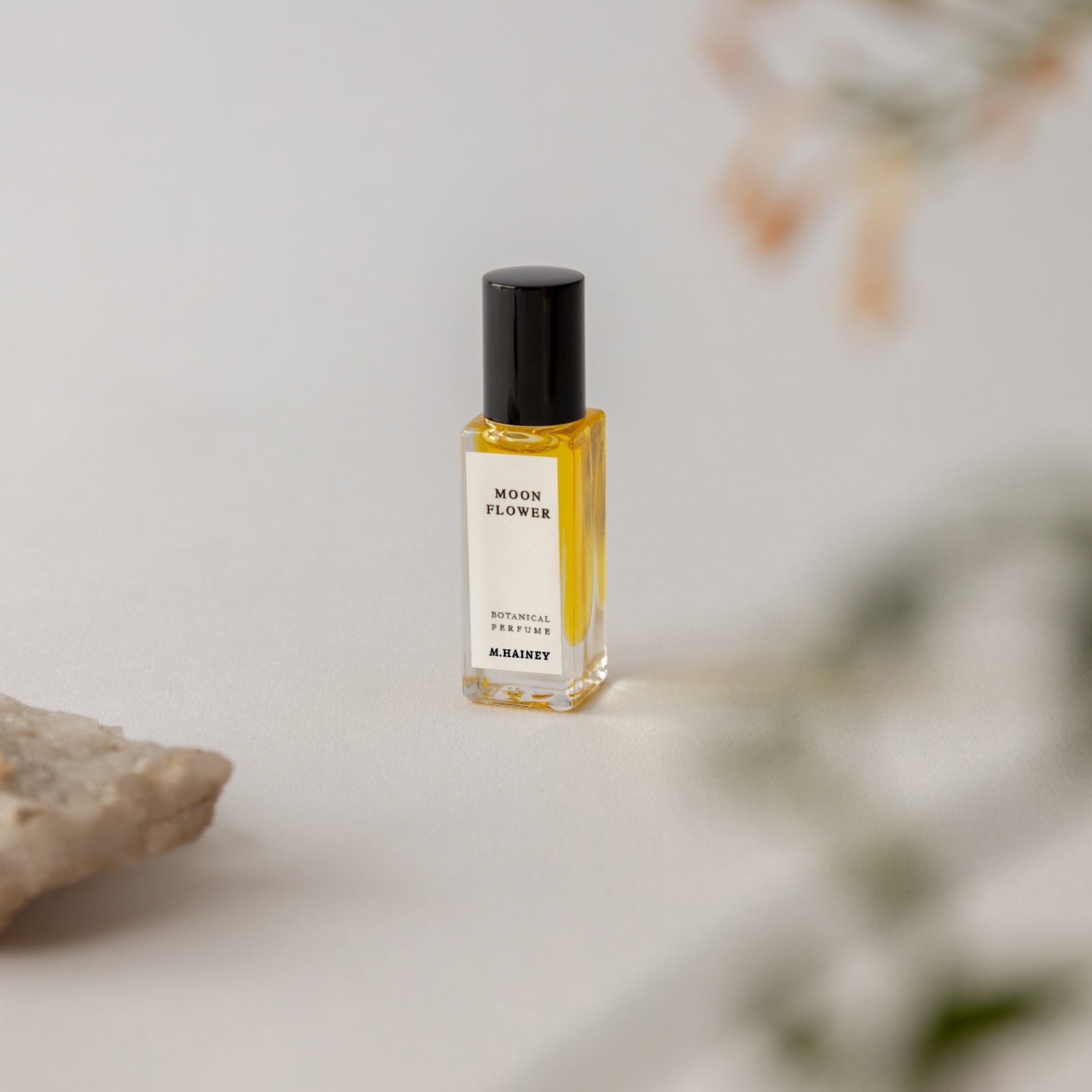 Perfume bottle labeled 'Moon Flower' by M. Micallef on a neutral background