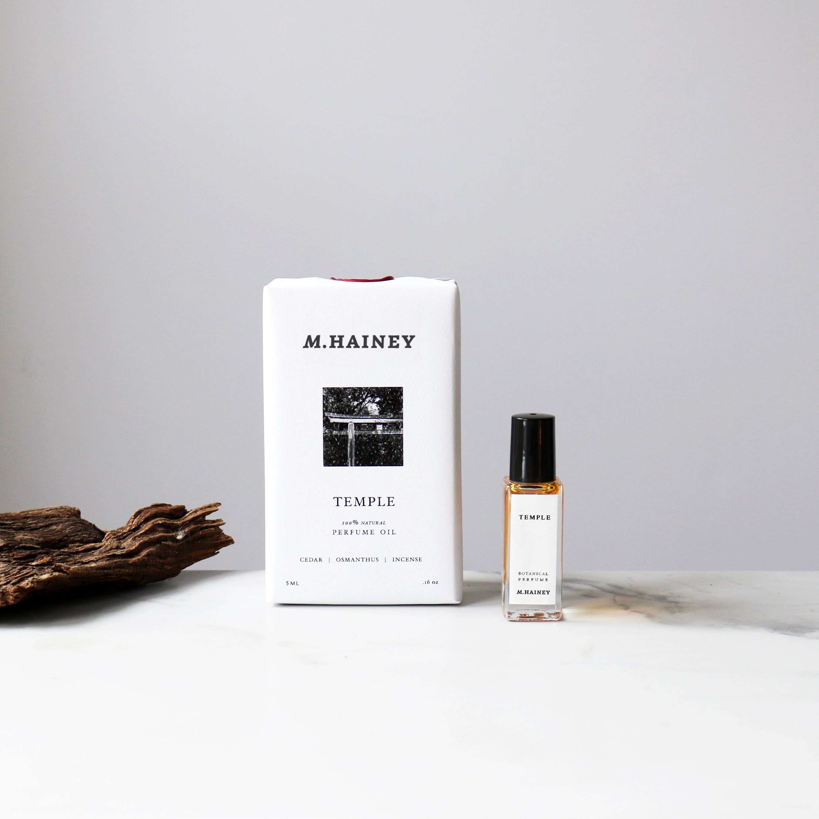 M.HAINEY Temple perfume bottle and packaging on a neutral background